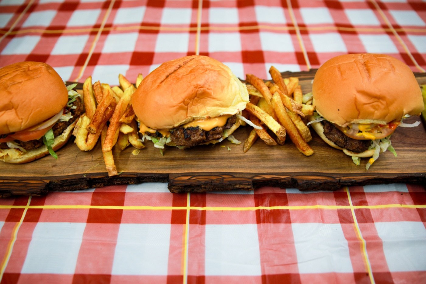 Smash burgers with fresh-cut fries on a wood board